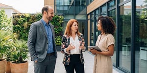 Three operational managers speaking outside of their office