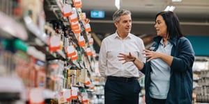 A supermarket worker and her manger walking through a supermarket