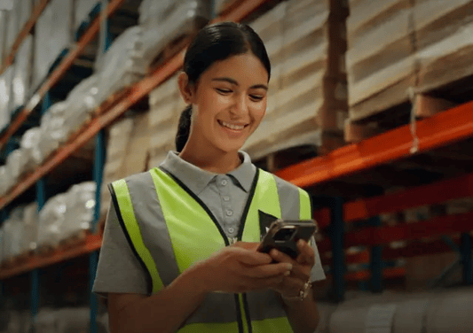 Warehousing staff looking at smartphone