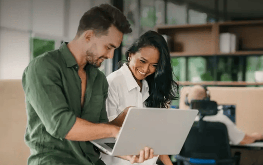 Act fast with real-time insights, colleagues looking at laptop together