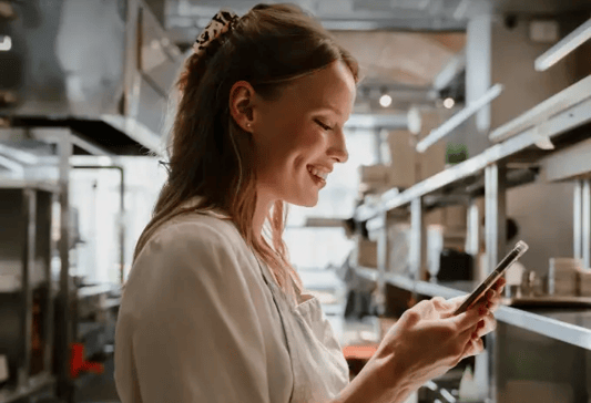 Real-time accountability, girl looking at her phone at work